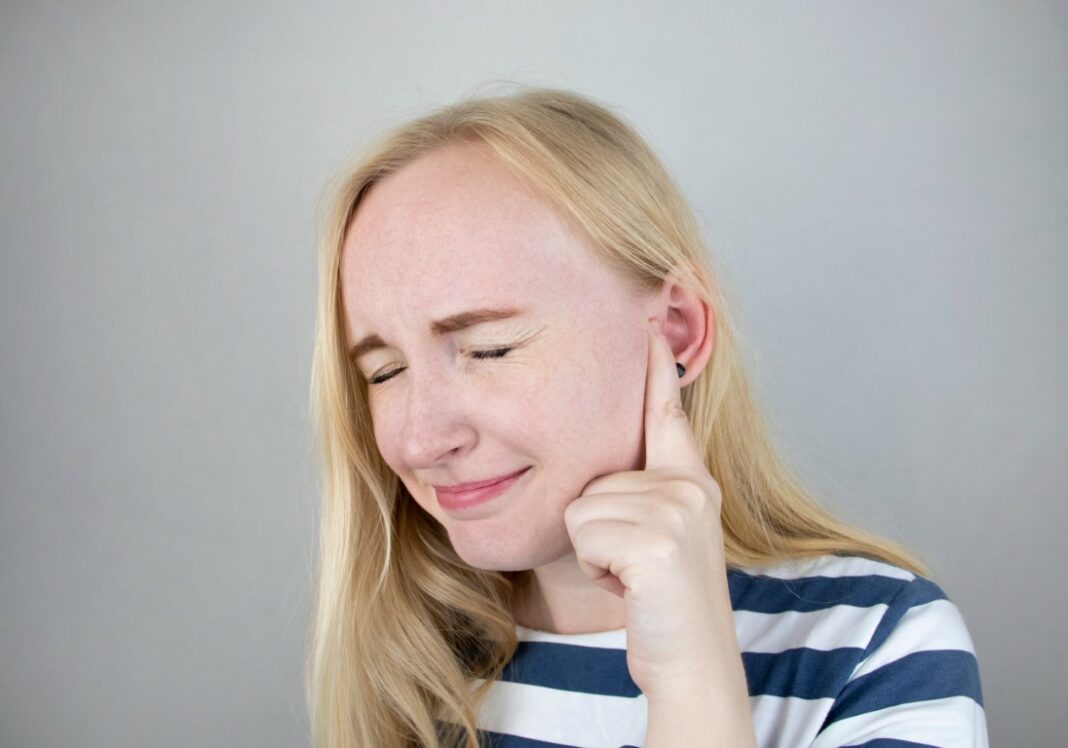 Femme souffrant à cause d'un bouchon d'oreille de cérumen